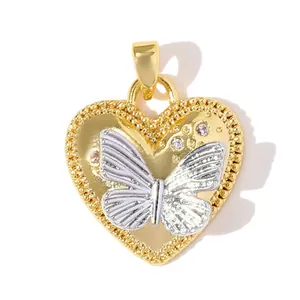 Detalle de colgante de corazón chapado en oro con mariposa plateada y circonitas