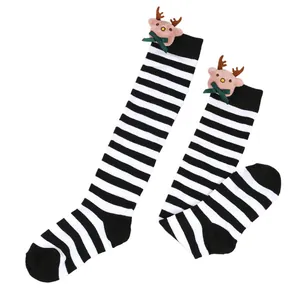 Close-up detail of children's black and white striped socks with cute reindeer plush doll