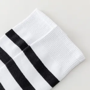 Détail du revers côtelé sur des chaussettes montantes à rayures noires et blanches