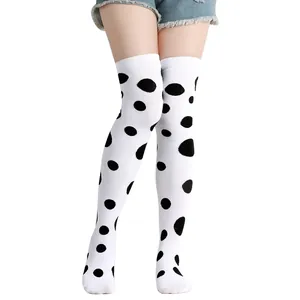 Close-up of stylish white over-the-knee socks with black dalmatian polka dot patterns