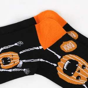 Close-up detail of Halloween pumpkin and skeleton knitted pattern on black cotton socks