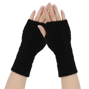 Close-up detail of black knitted fingerless gloves showing the classic cable knit texture.