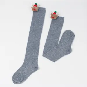 Detail of grey over-the-knee Christmas socks with cute plush reindeer decorations