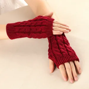 Close-up showing the warm red cable knit texture and fingerless design of winter gloves