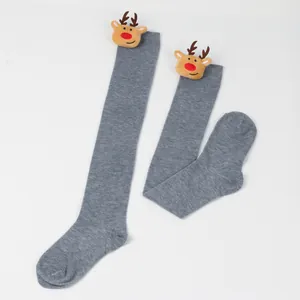 Detail view of grey over-the-knee Christmas socks with cute plush reindeer heads