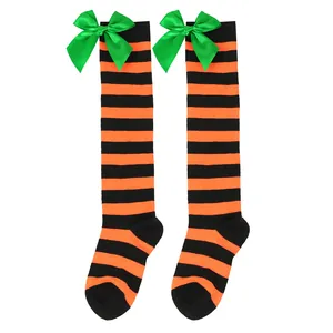 Festive girls orange and black striped over-the-knee socks with green satin bows