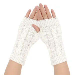 Detailed view of white cable knit fingerless gloves showing texture and fit on human hands