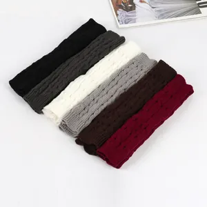 Dettaglio degli scaldabraccia in maglia a trecce in vari colori invernali come nero