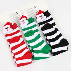 Detailed view of striped children's Christmas socks with cute plush Santa Claus dolls attached.
