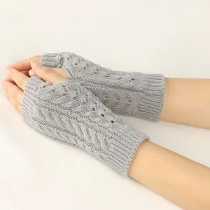 Close-up of grey cable knit fingerless gloves with elegant hollow pattern detail.