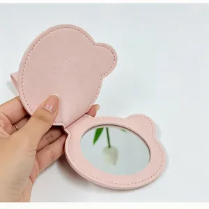 Vue détaillée d'un miroir de maquillage de voyage pliable en cuir PU rose en forme d'ours