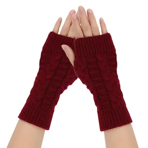 Macro detail of burgundy cable-knit fingerless gloves designed for winter warmth and outdoor use