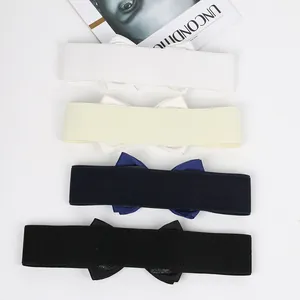 Detailed view of elastic bow waist belts in white, cream, navy blue, and black colors