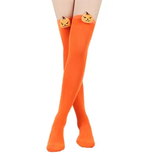 Detail shot of orange Halloween over-the-knee socks with cute pumpkin plush figures.