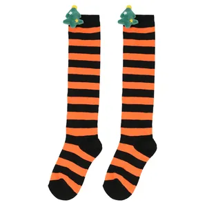 Detailed view of striped children's knee-high Christmas socks with cute plush tree doll