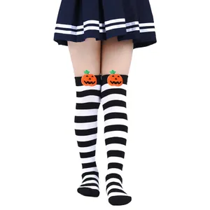 Macro view of Halloween striped over-the-knee socks featuring cute plush pumpkin dolls