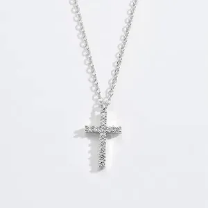 Close-up of elegant silver cross pendant necklace with sparkling moissanite stones