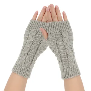 Grey cable knit fingerless gloves showing detailed arm warmer texture and ribbed cuffs
