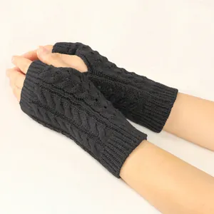 Close-up of black cable-knit fingerless gloves with hollow pattern detail