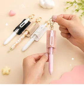 Detalle de funda para bolígrafo rosa de cuero PU con llavero sostenida por manos en uso