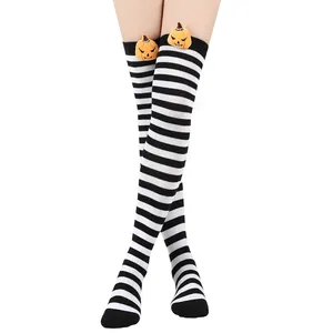 Detailed view of Halloween striped over-the-knee socks with cute plush pumpkin doll decor.