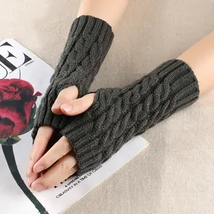 Detail of dark grey knit fingerless gloves with a classic twist braid pattern