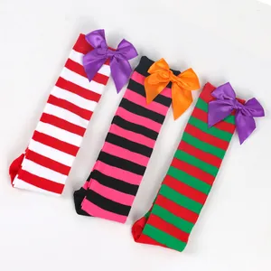 Detailed close-up of three colorful striped Halloween over-the-knee socks with satin bow accents.