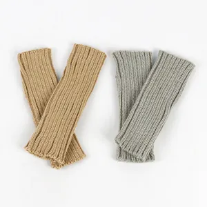 Détail rapproché de mitaines en maille côtelée de couleur camel et gris chiné