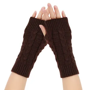 Detailed view of brown knitted fingerless gloves worn on hands for winter warmth.