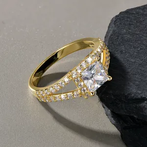 Detailaufnahme eines 14k vergoldeten Rings mit Kreuzschaft und quadratischem Zirkon
