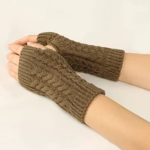 Close-up shot of warm brown cable knit fingerless gloves with detailed openwork pattern