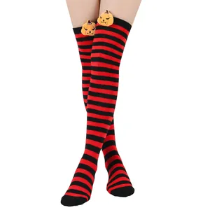 Detail of red and black striped over-the-knee socks with plush pumpkins for Halloween party COS