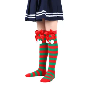Detailed view of kids' Christmas over-the-knee socks with red bows and white pompoms