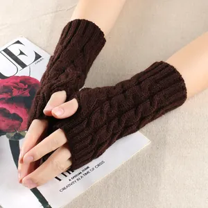 Detailed macro view showing the cable knit pattern of dark brown fingerless winter gloves