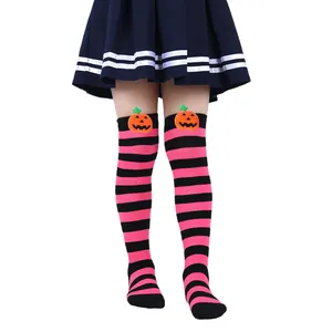 Detailed view of pink and black striped kids Halloween socks with pumpkin plush detail.