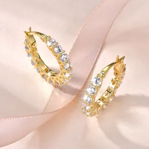 Vista detallada de pendientes de aro de lujo chapados en oro 14k con circonitas.