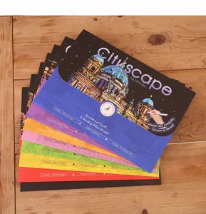 A stack of colorful Cityscape scratch painting sheets on a natural wooden background.