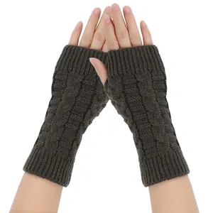 Close-up of dark brown cable knit fingerless gloves for winter warmth and outdoor use.