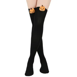 Close-up of black over-the-knee socks with cute Halloween pumpkin plush details