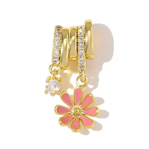 Close-up of a gold-plated daisy pendant featuring pink enamel and zircon stones