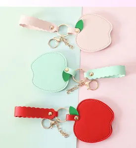 Detailed view of apple-shaped PU leather mirror keychains in pink, green, and red colors.