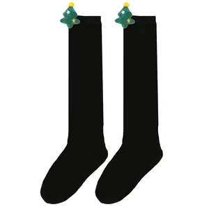 Detailed view of black over-the-knee children's socks with a plush Christmas tree