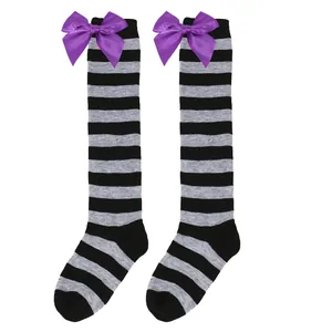 Detailed view of children's grey and black striped knee high socks with purple satin bows