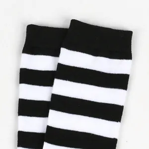 Close-up detail showing the knit texture of black and white striped long tube socks for kids