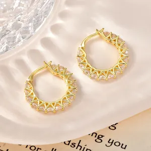 Primer plano de pendientes de aro bañados en oro de 14k con pavé de circonitas claras