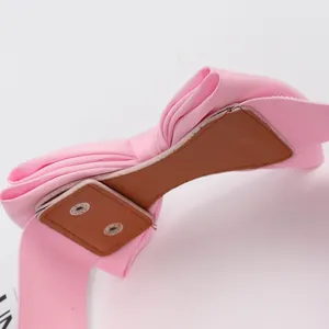 Close-up of pink chiffon bow belt with double metal snap closure mechanism