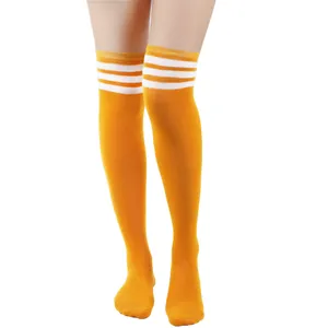 Detailweergave van gele over-de-knie sokken met klassieke witte strepen op modelbenen