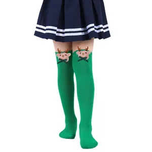 Detailed view of green children's Christmas over-the-knee socks with cute reindeer plushies