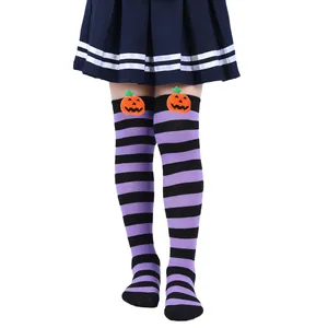 Detailed macro view of children's purple striped Halloween over-the-knee socks with plush pumpkins