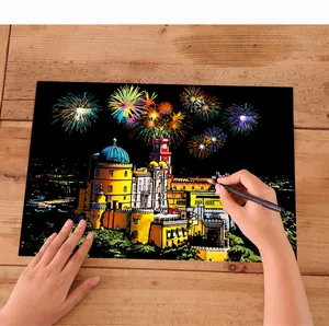 Close-up detail of hand using scratch tool on city landscape scratch art paper with fireworks